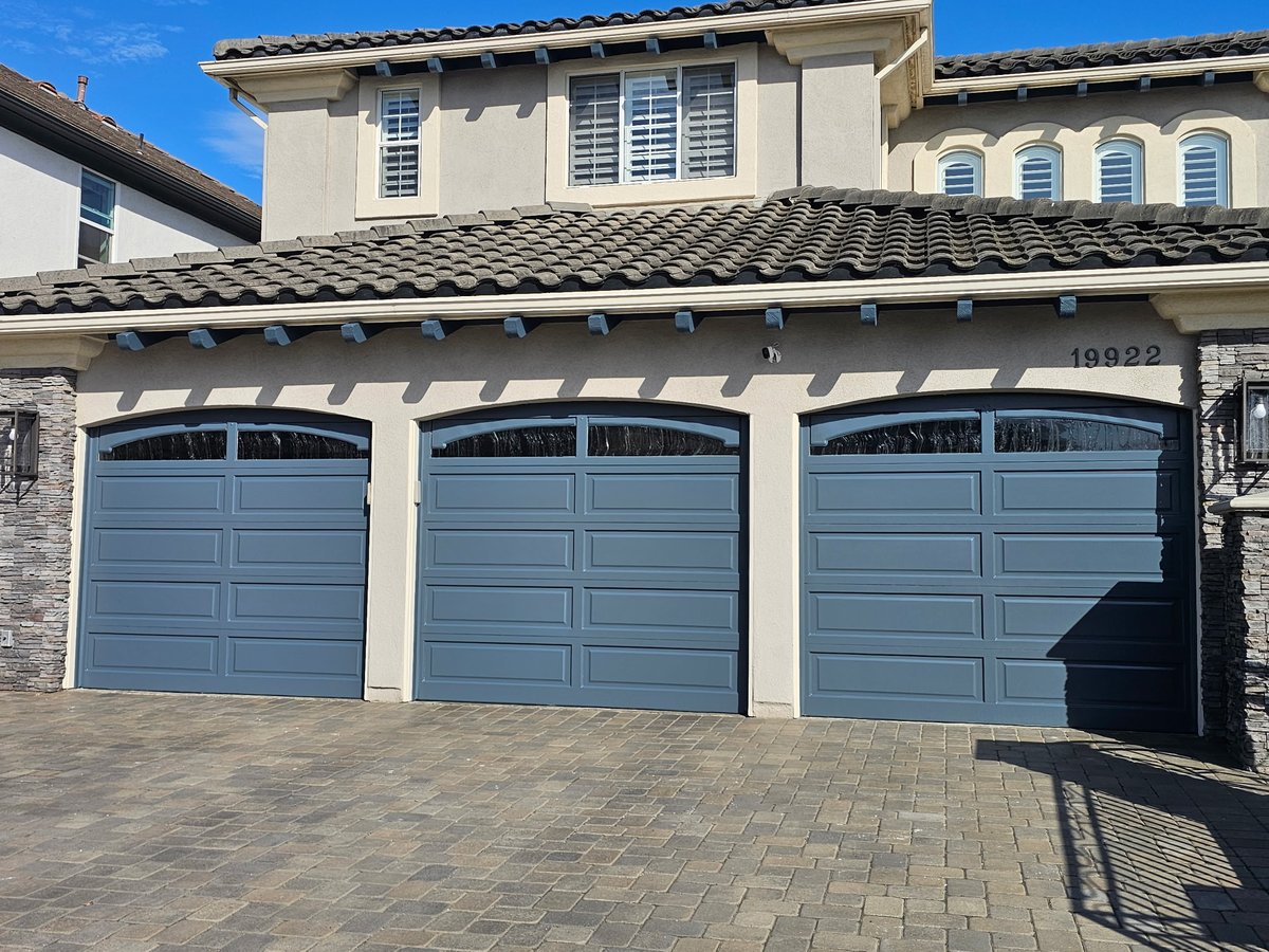 After: garage doors repainted in a soft blue-gray finish