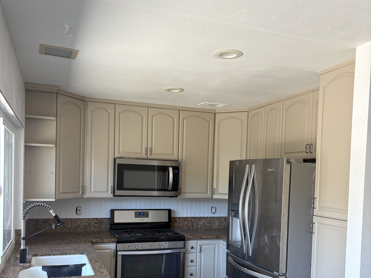 After: kitchen cabinets refinished in a warm cream with updated hardware