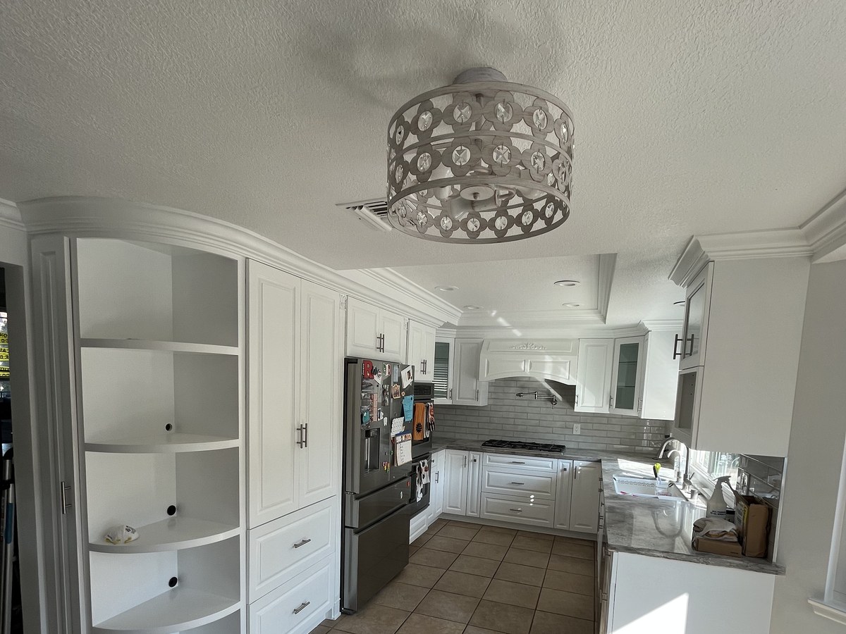 After: curved built-in kitchen cabinetry refinished in white