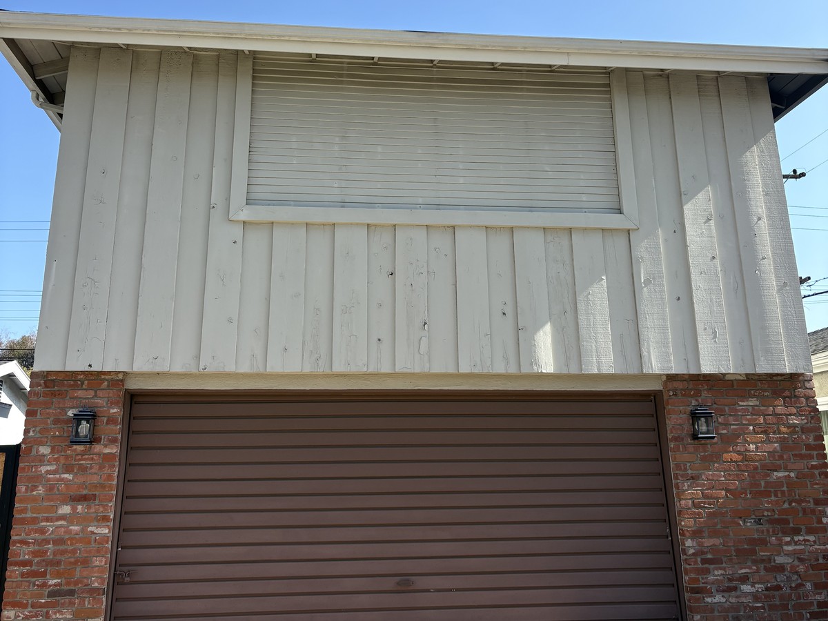 Before: original worn wood siding and driveway