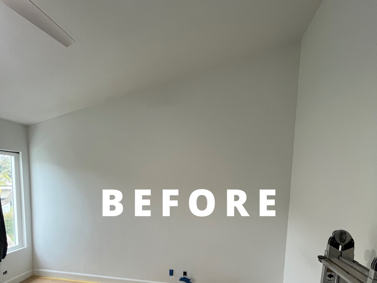 Before: bare white bedroom wall before painting