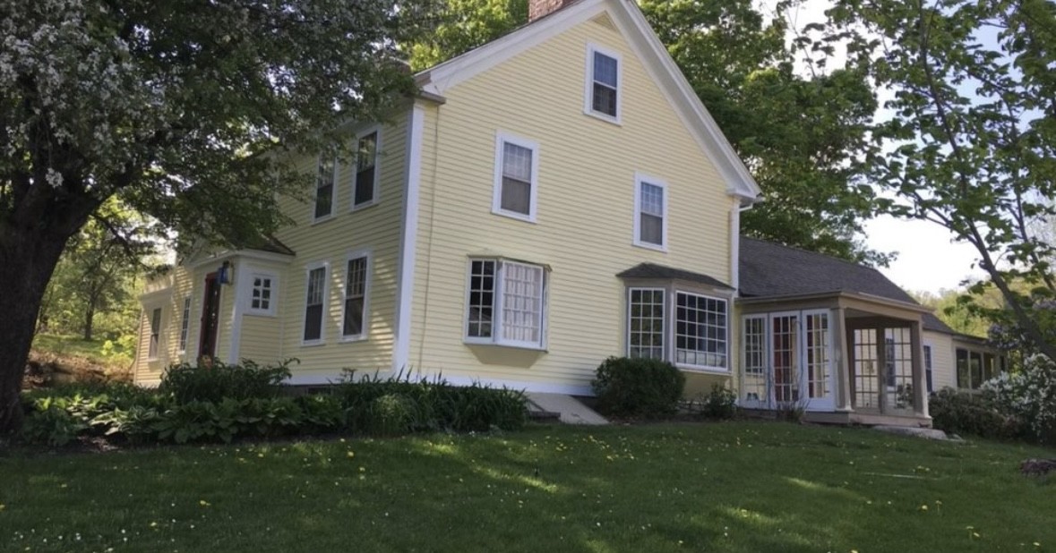 Classic New England-style home with fresh yellow exterior paint and white trim