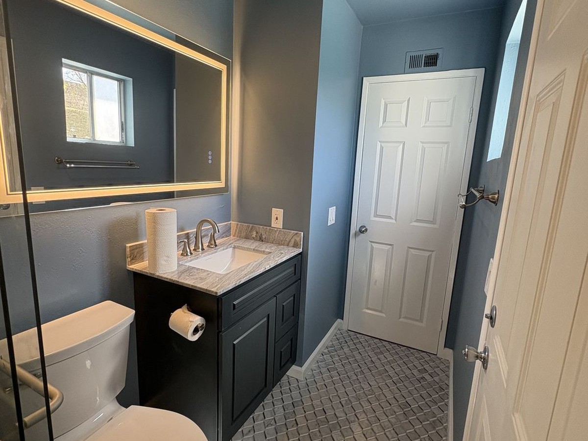 Fully renovated bathroom with new tile flooring, vanity, mirror and fresh paint