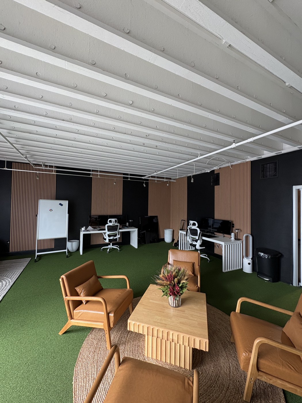 Finished custom wood-slat accent walls in a furnished lounge and workspace area