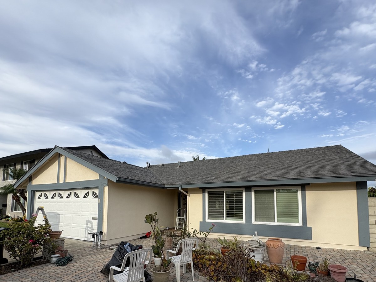 Completed exterior repaint with fresh slate-blue trim on an overcast day
