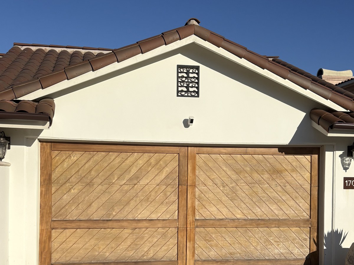 After: garage door refinished with a rich wood-grain stained finish