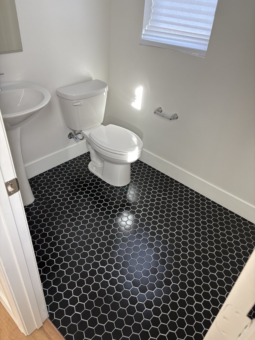 Black hexagon tile flooring installed in a bathroom