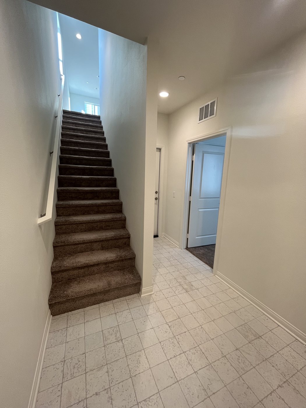 Tile flooring installed in an entry hallway leading to a staircase