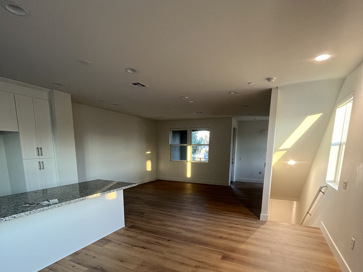 New wood-look flooring flowing from a kitchen into a living area