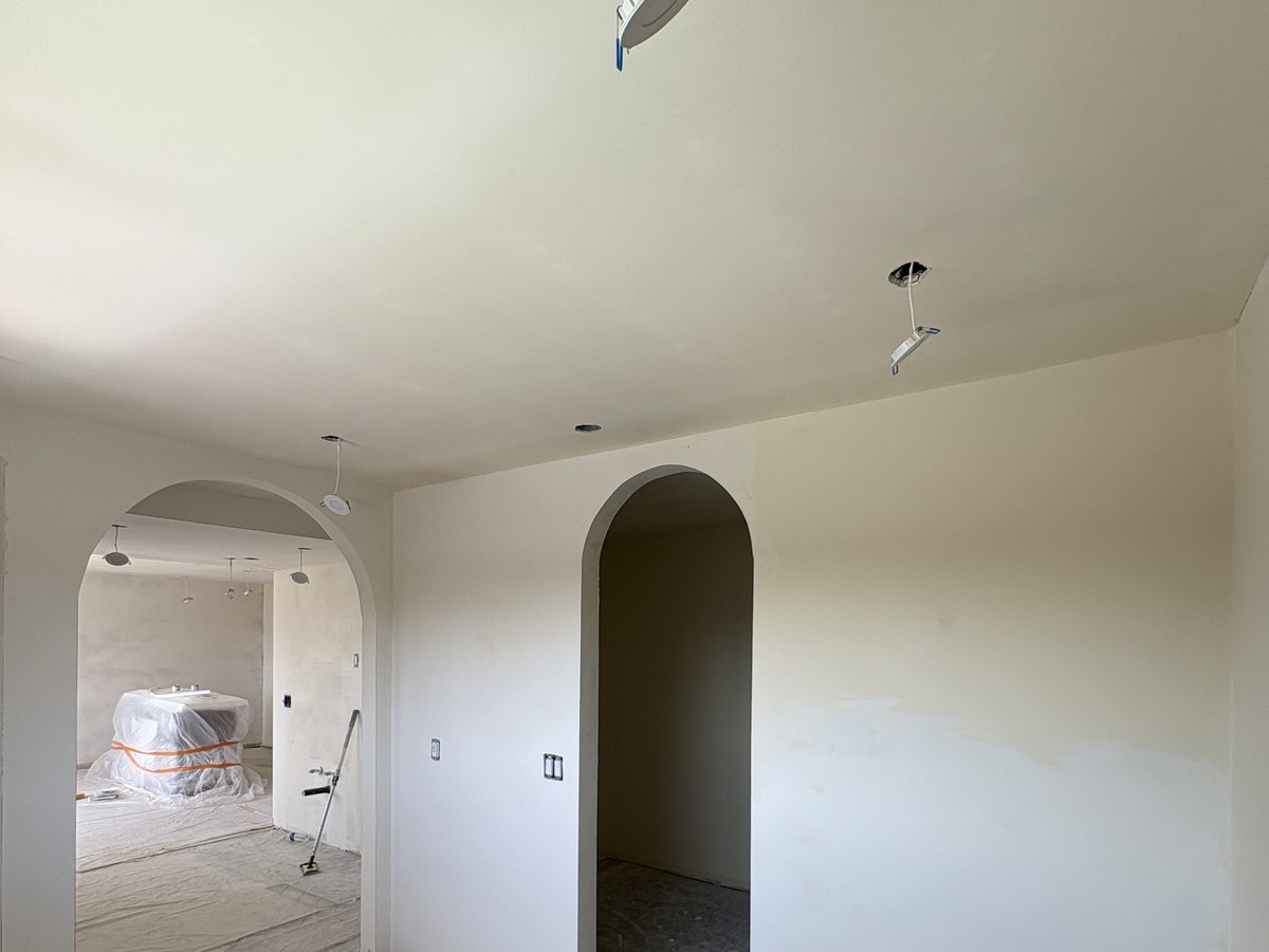 Freshly finished drywall with a custom arched doorway, ready for paint