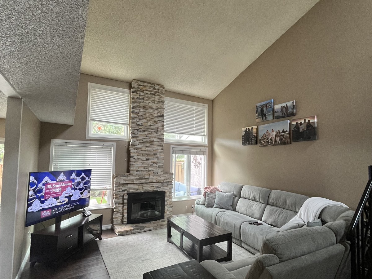 Living room with a stone fireplace and freshly painted walls