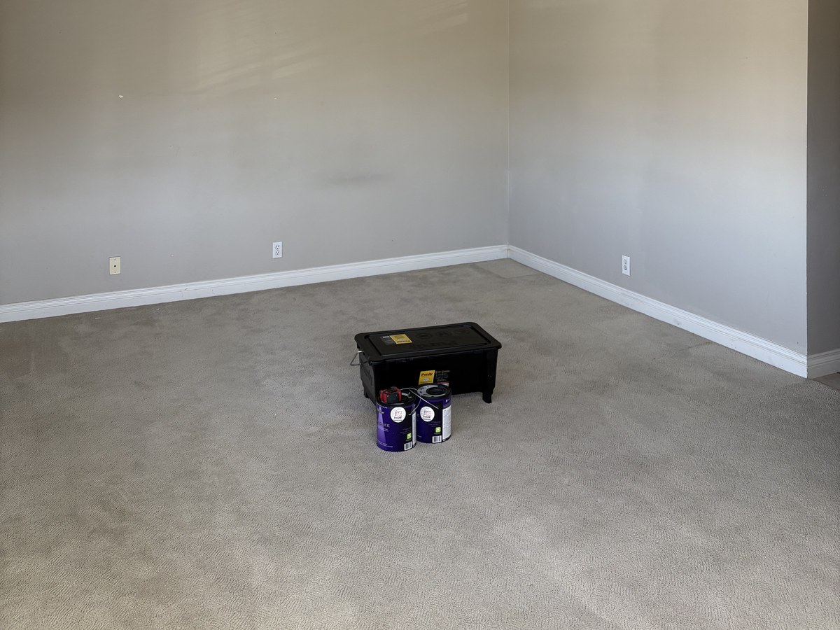 After: bedroom walls repainted in a soft warm gray