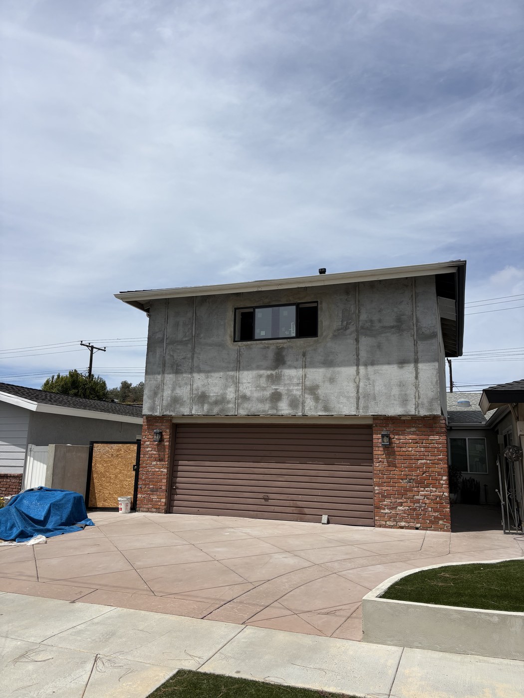 House with newly re-stuccoed exterior and a new stamped concrete driveway