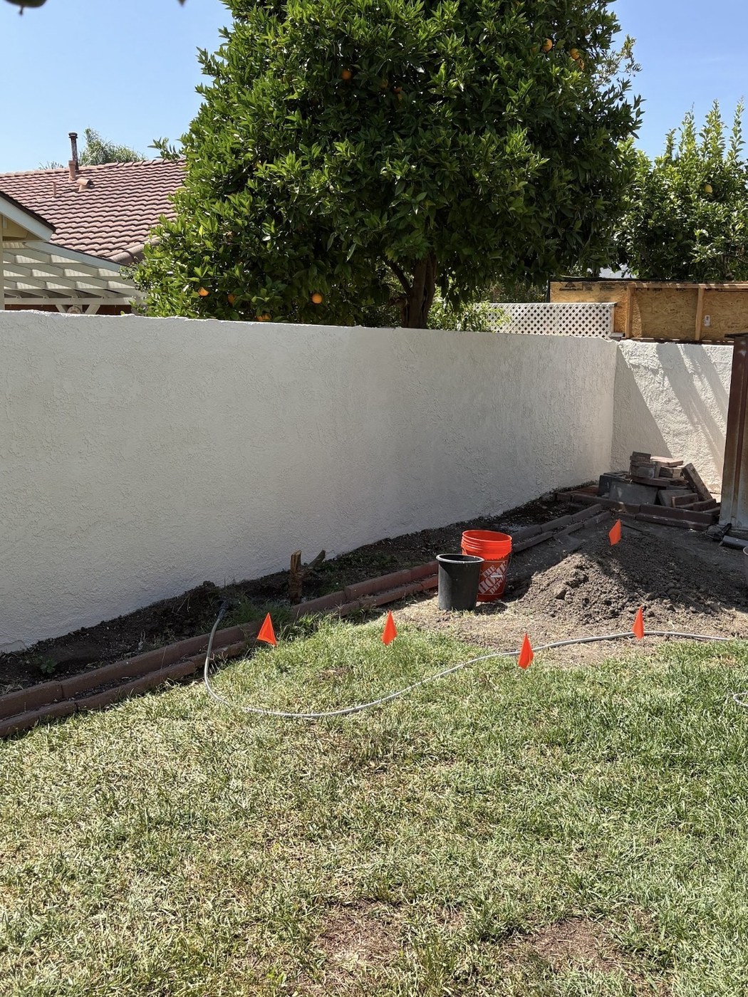 Backyard wall with a stair-step crack repaired and freshly painted white